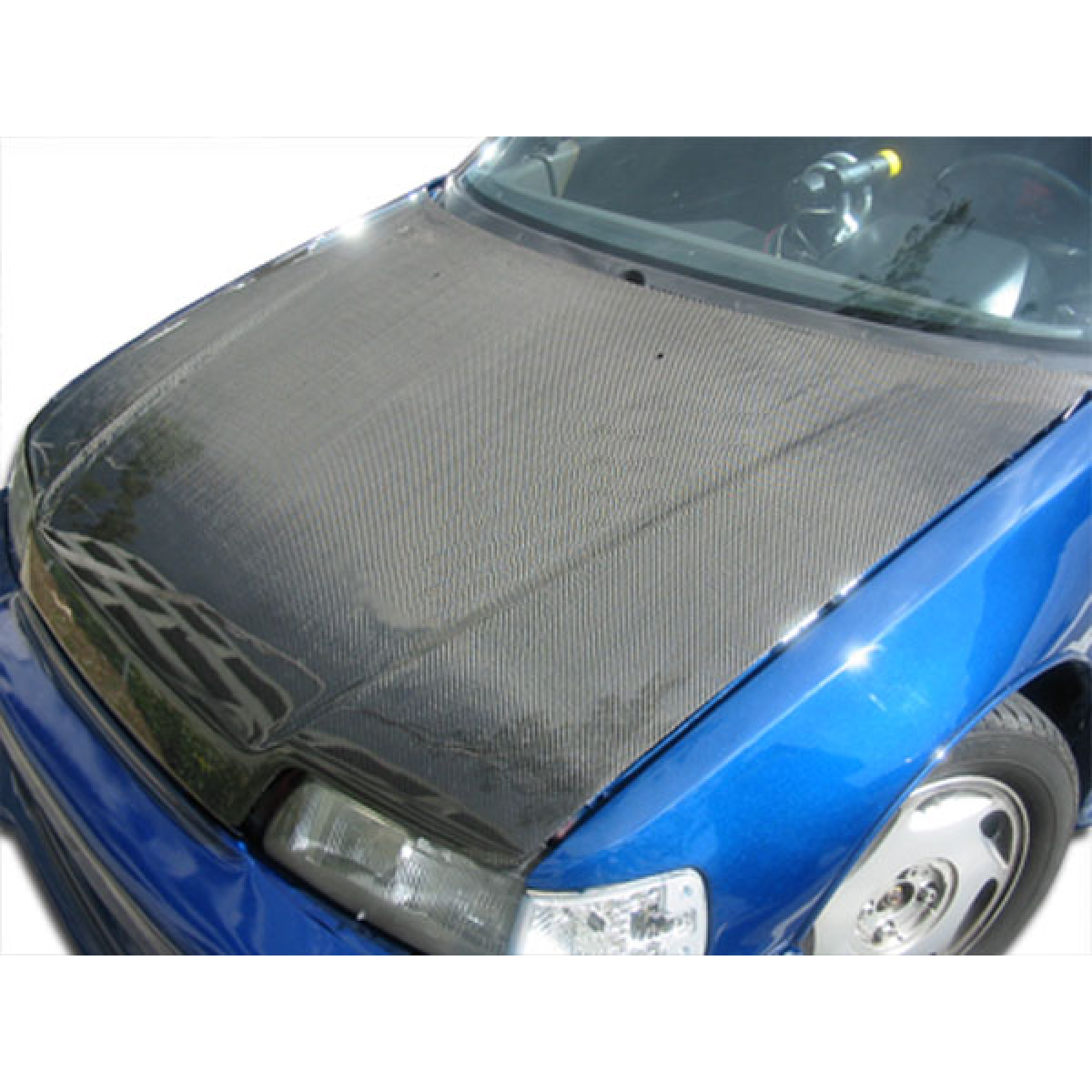 Modify your Honda Civic 1988 with our Exterior/Hoods - Angled view of carbon fiber hood on blue Honda Civic