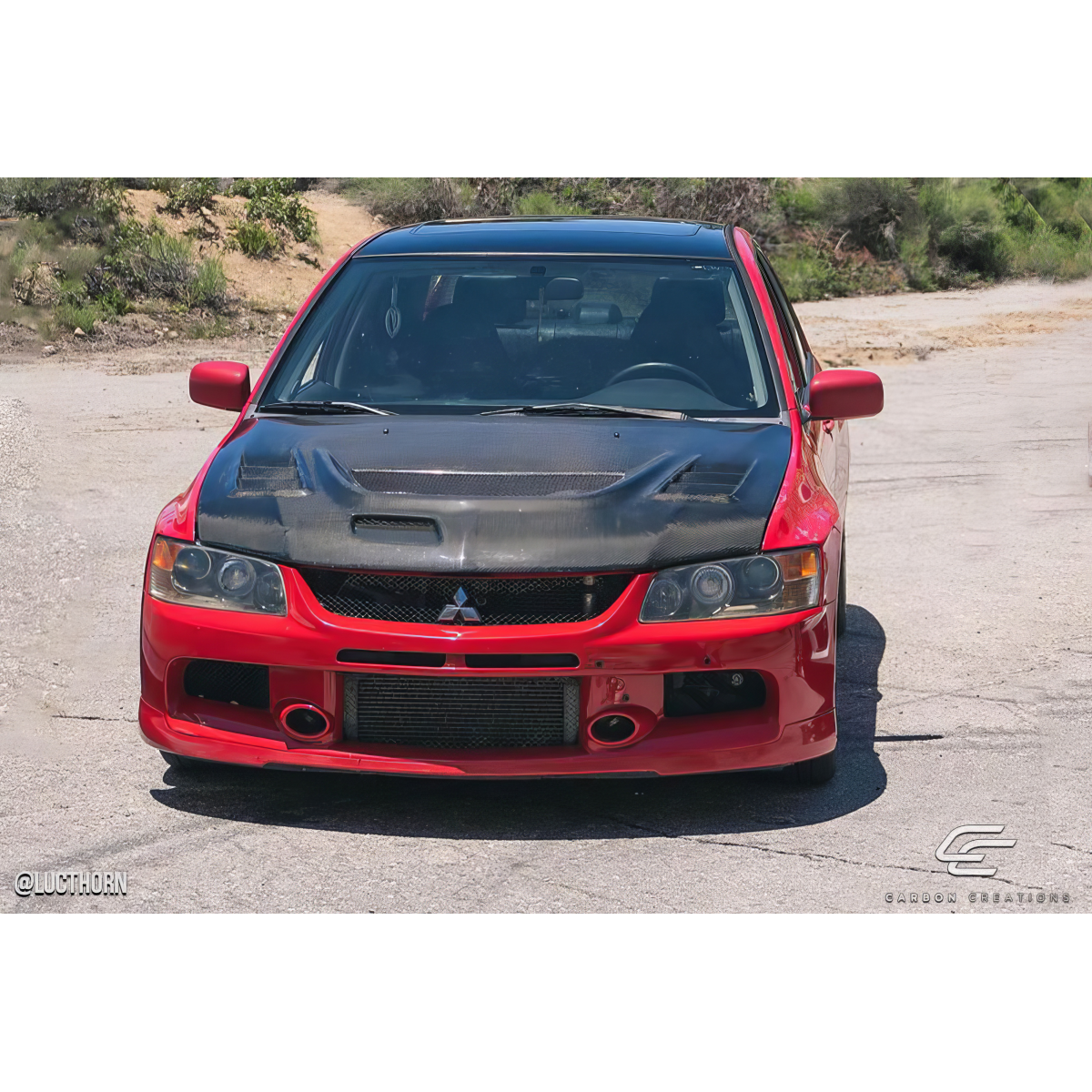 Modify your Mitsubishi Evolution 2003 with our Exterior/Hoods - Front view of the vehicle at a slight angle