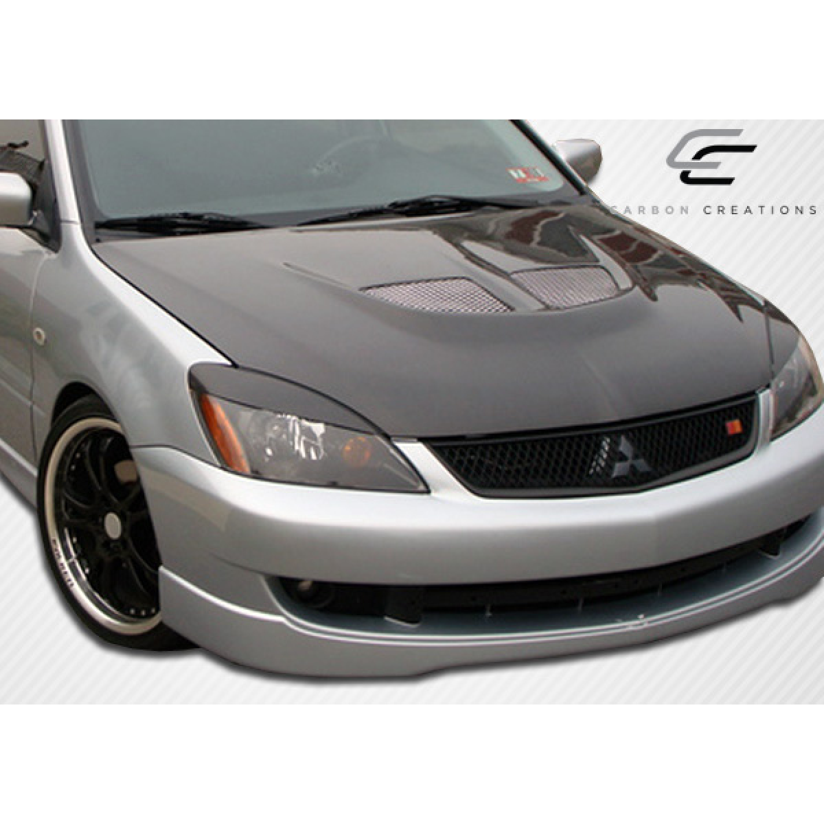 Modify your Mitsubishi Lancer 2004 with our Exterior/Hoods - Front angle view of the hood part