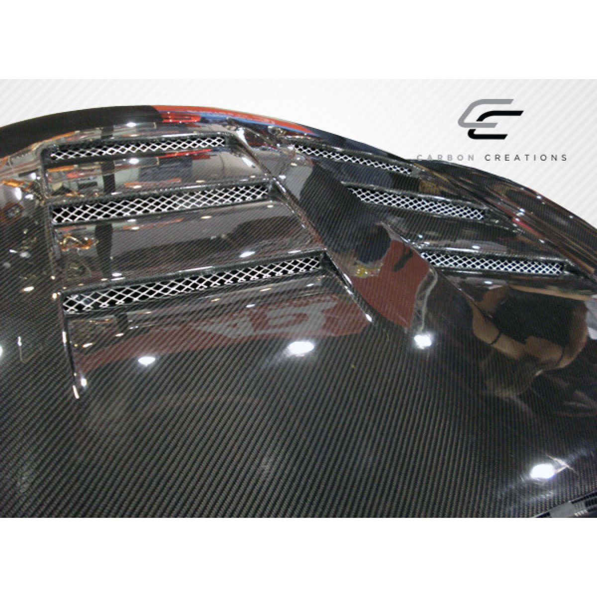 Modify your Infiniti G37 2008 with our Exterior/Hoods - Top down view of carbon fiber hood at slight angle