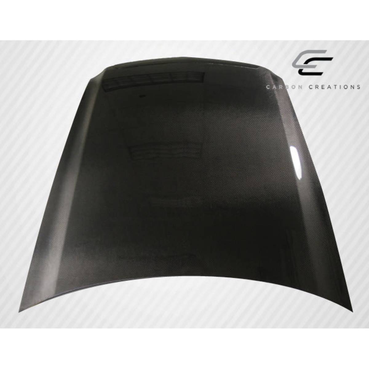 Modify your Acura TL 2004 with our Exterior/Hoods - Angled view of a carbon fiber hood part