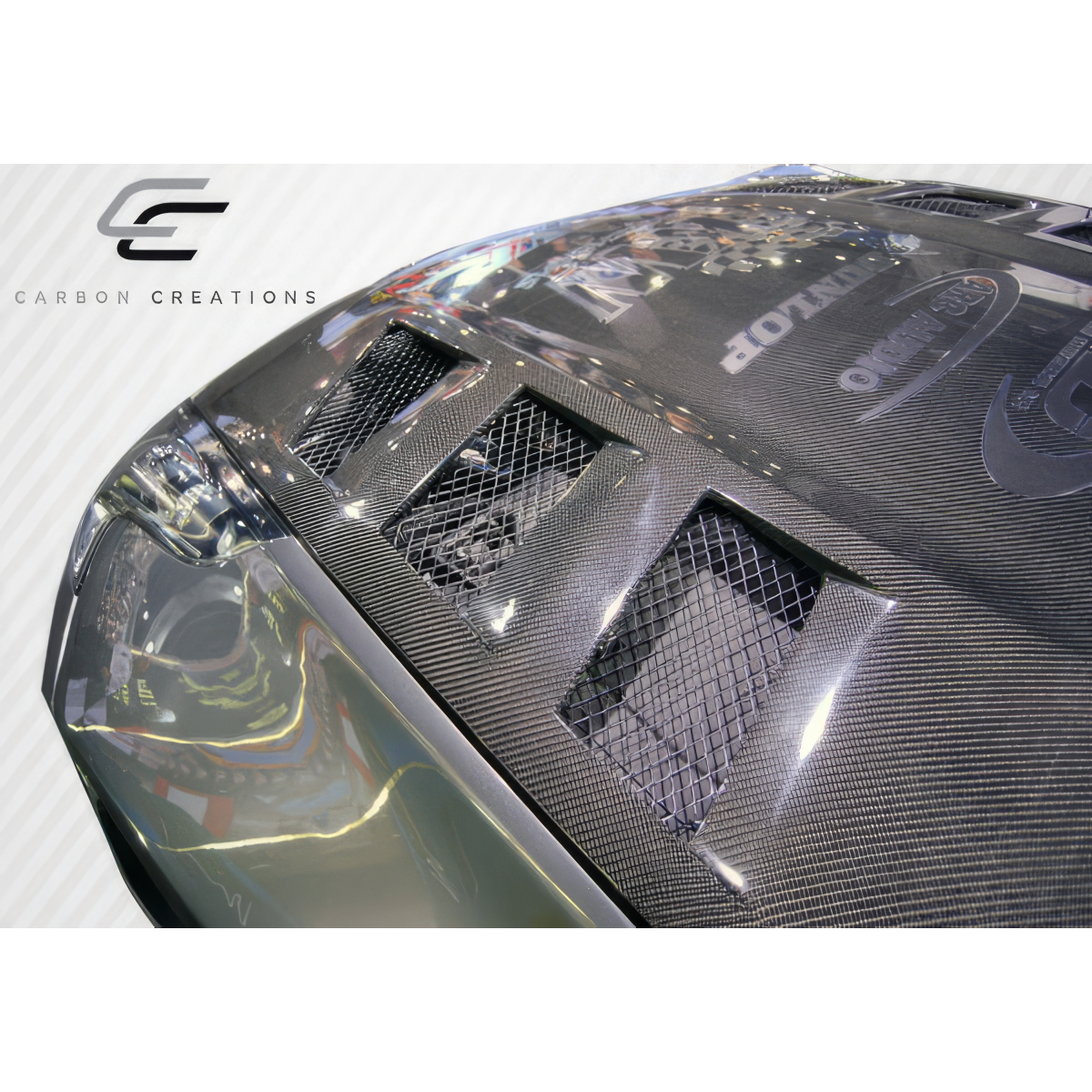 Modify your Nissan 370Z 2009 with our Exterior/Hoods - Angled view of car hood showing carbon fiber finish