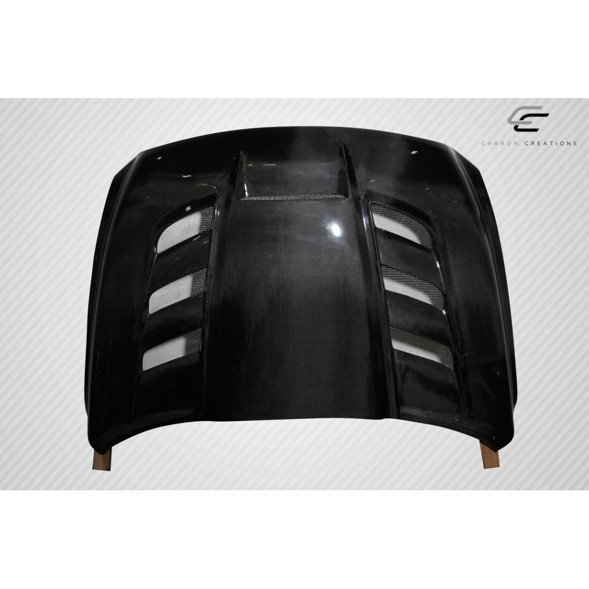 Modify your Dodge Ram 2009 with our Exterior/Hoods - Front view of carbon fiber hood at a slight angle