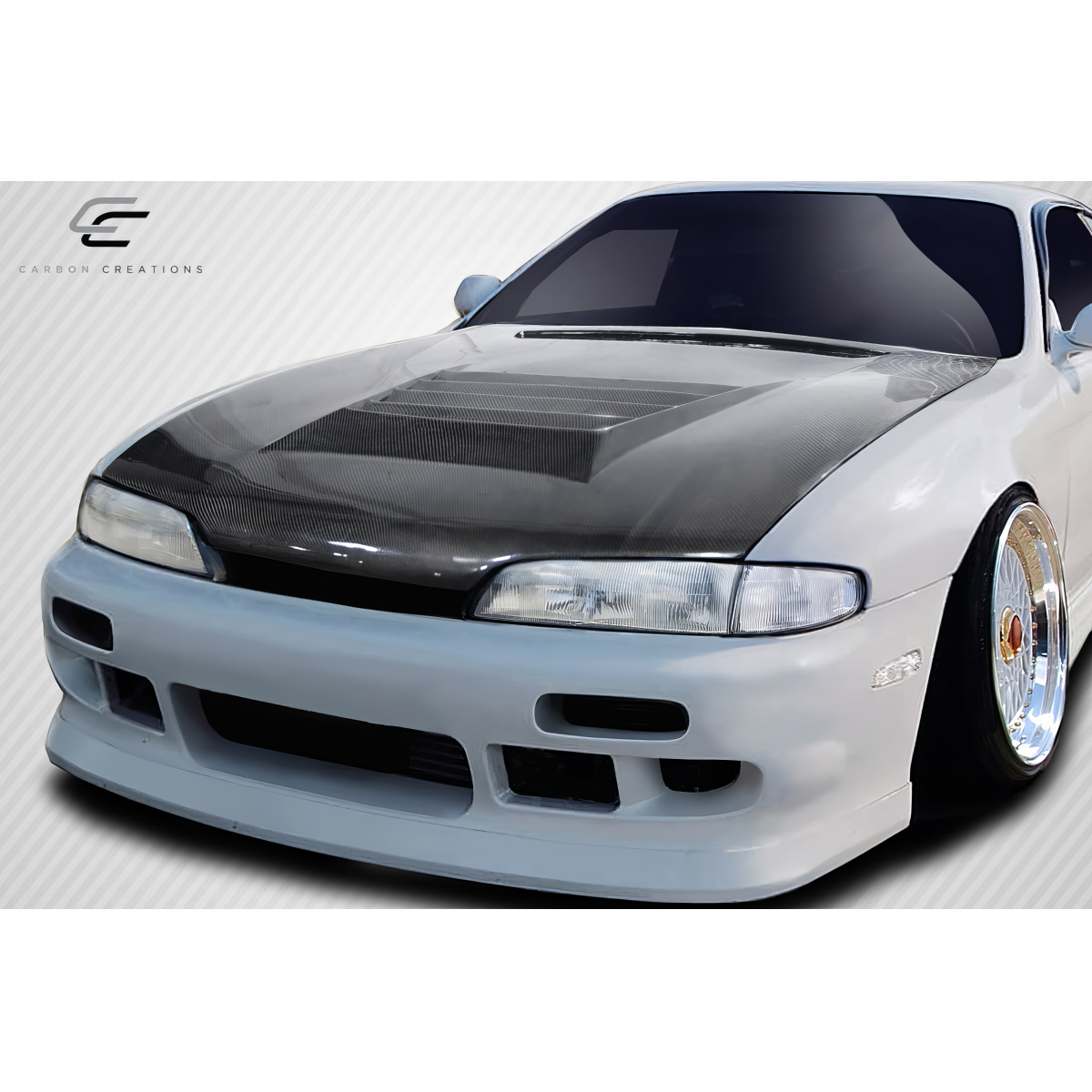 Modify your Nissan 240SX 1995 with our Exterior/Hoods - Front angle view of a carbon fiber hood