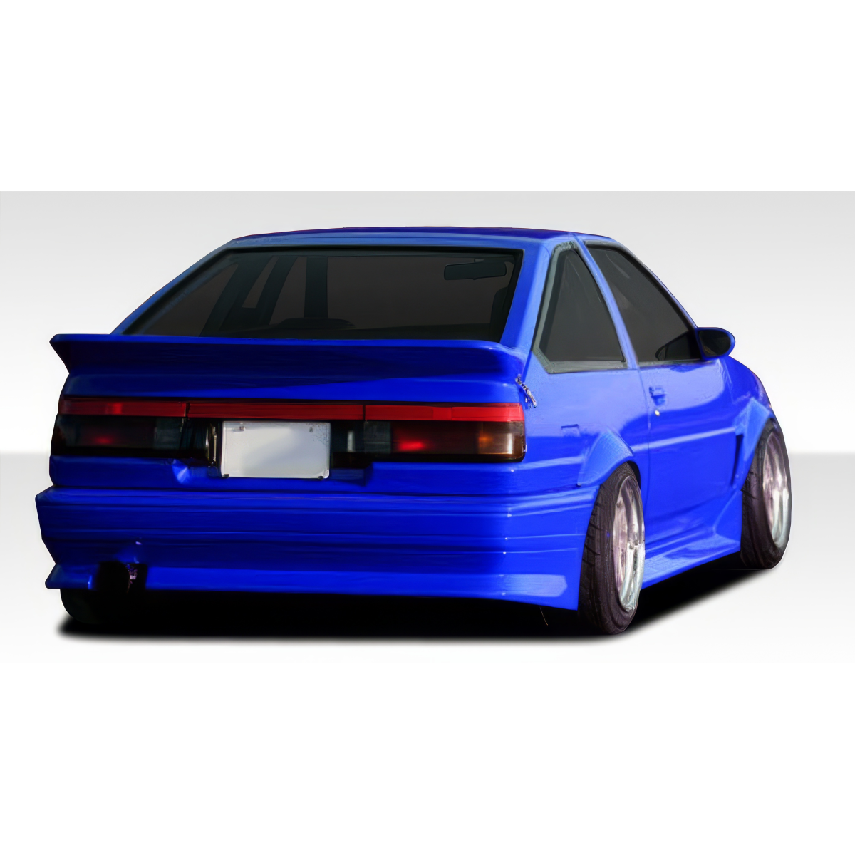 Modify your Toyota Corolla 1984 with our Exterior/Rear Bumpers or Lips - Rear angle view of a modified blue Toyota Corolla