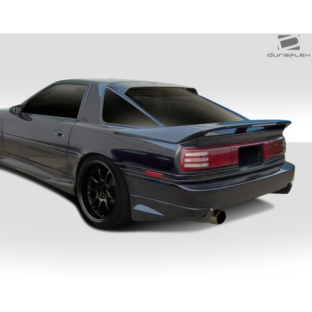 Modify your Toyota Supra 1986 with our Exterior/Rear Bumpers or Lips - Rear angle view of a vehicle's rear bumper