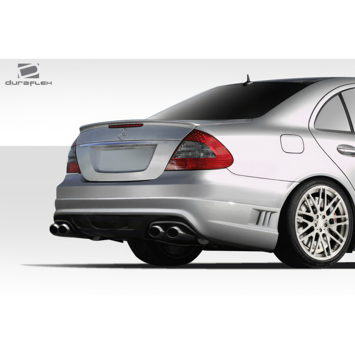 Modify your Mercedes-Benz E55 AMG 2003 with our Exterior/Rear Bumpers or Lips - Rear angle view of the vehicle showing bumper